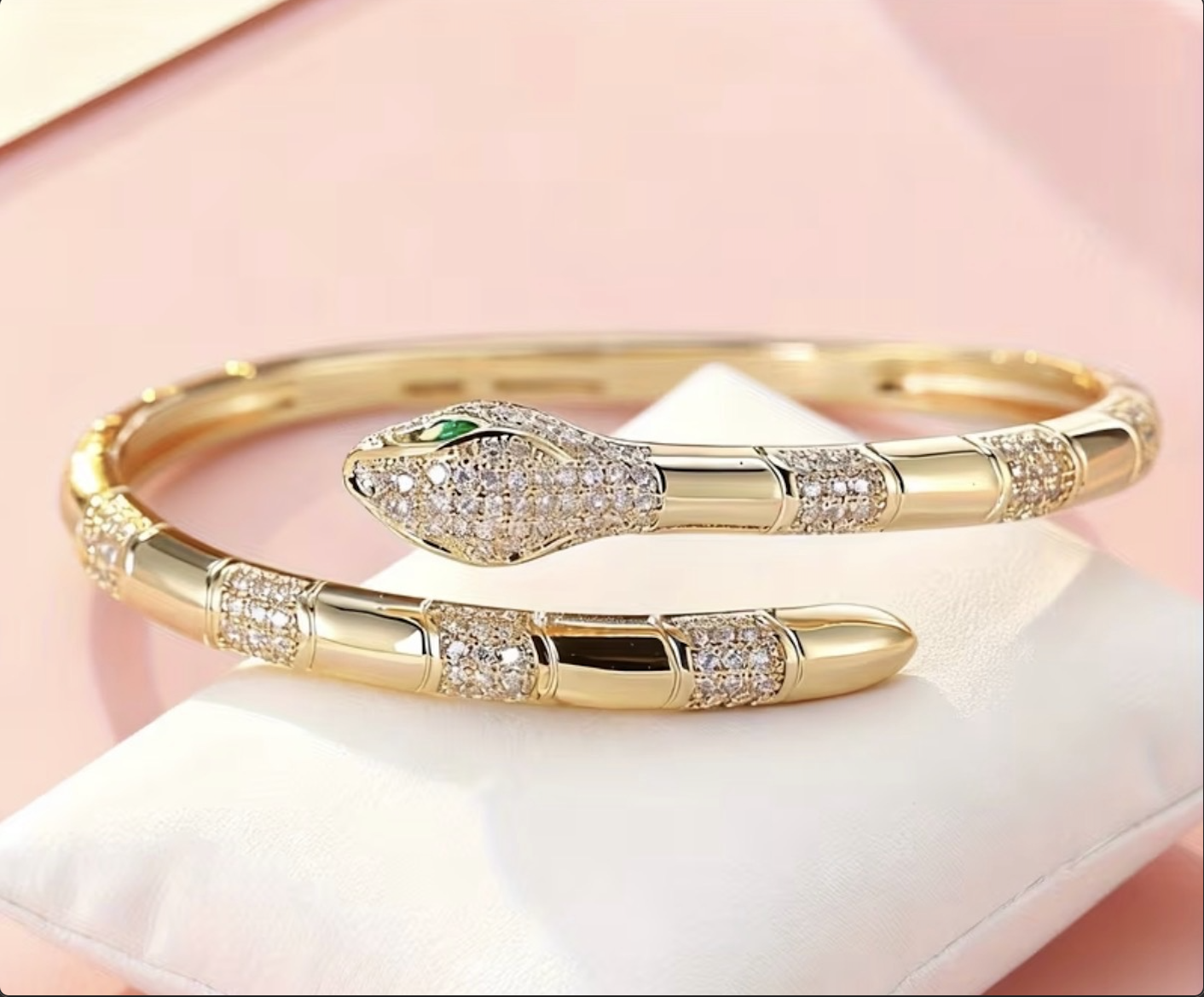 Gold serpent bangle with crystal detailing and emerald eye